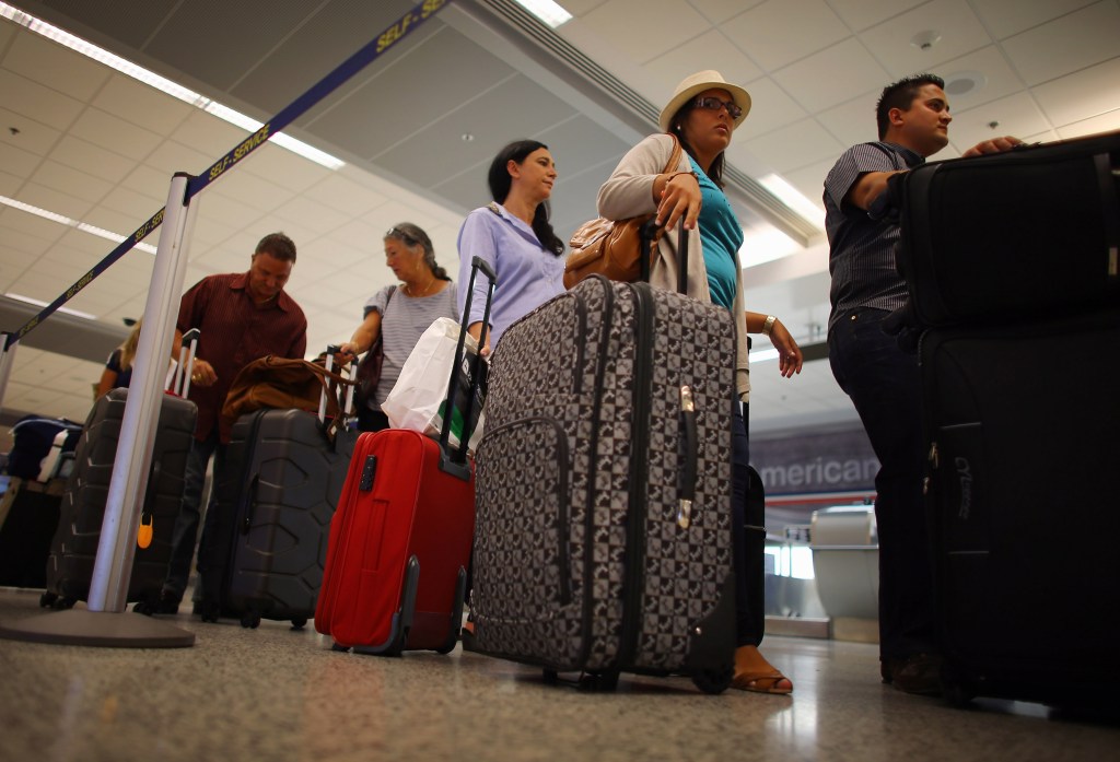 Travelers wait in line at the American Airlines ticket counter at Miami International Airport on September 25, 2012 in Miami, Florida.